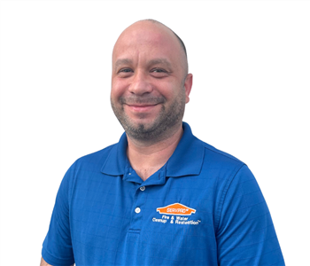 Man with beard in a blue SERVPRO shirt against white backdrop